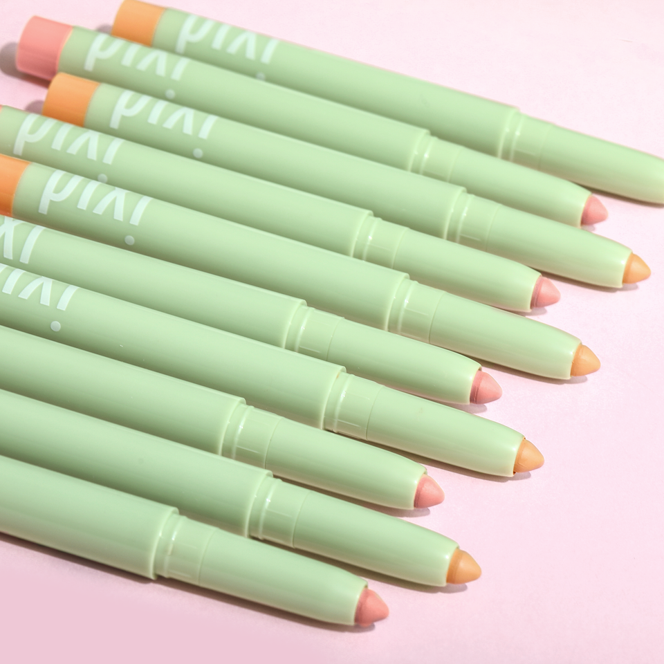 Six PiXi makeup CC Crayon with pale mint green packaging arranged diagonally on a light pink background. view 2