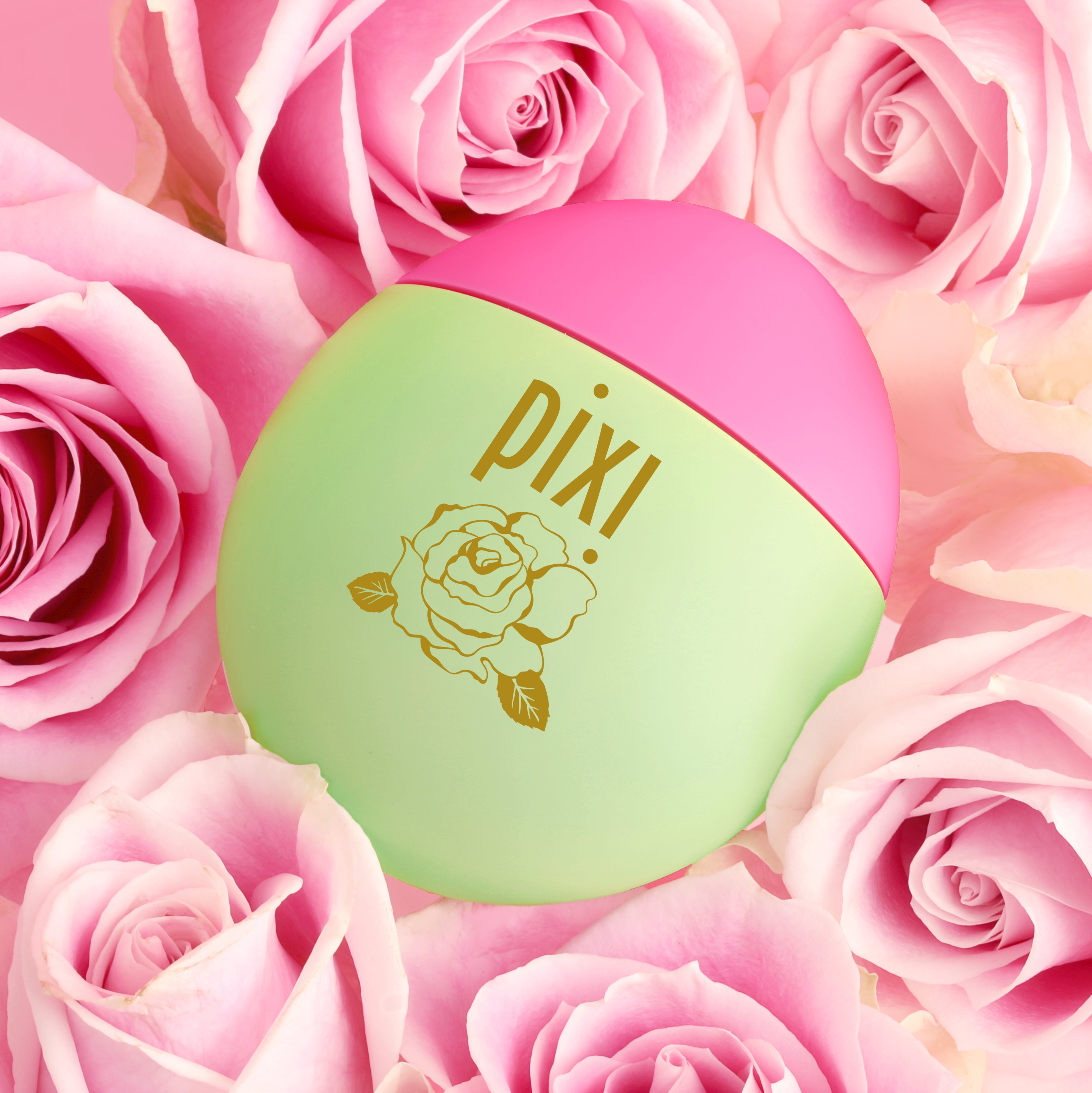 Pixi HandHero PixiRose scented product arranged among pink roses on a pink background. Hydrated hands with signature Pixi scents.
